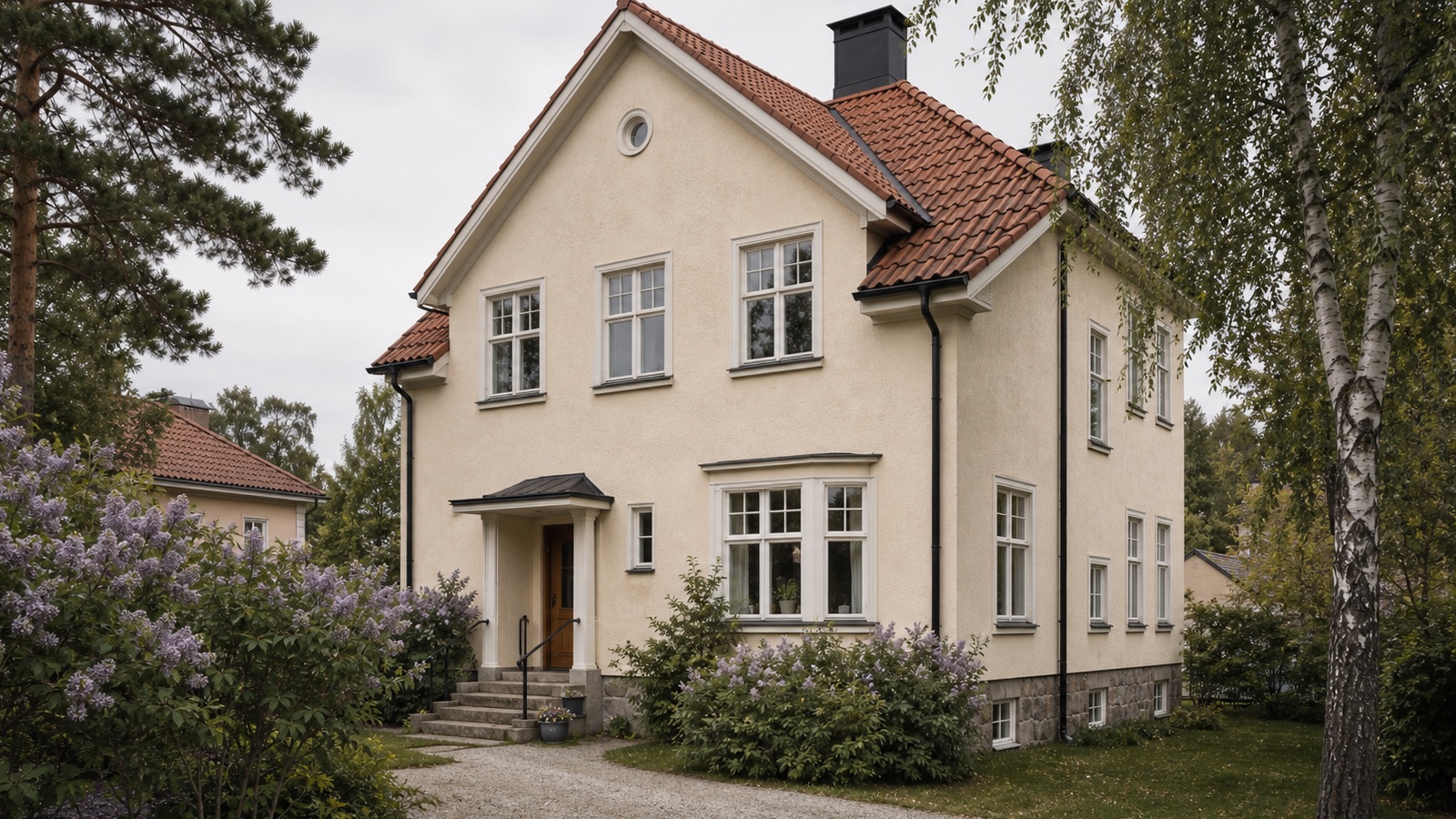 Ljus putsfasad med stora fönster i arkitektoniskt uttryck